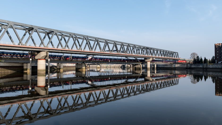 A steel bridge reflecting in calm waters, capturing Hamburg's serene morning atmosphere.